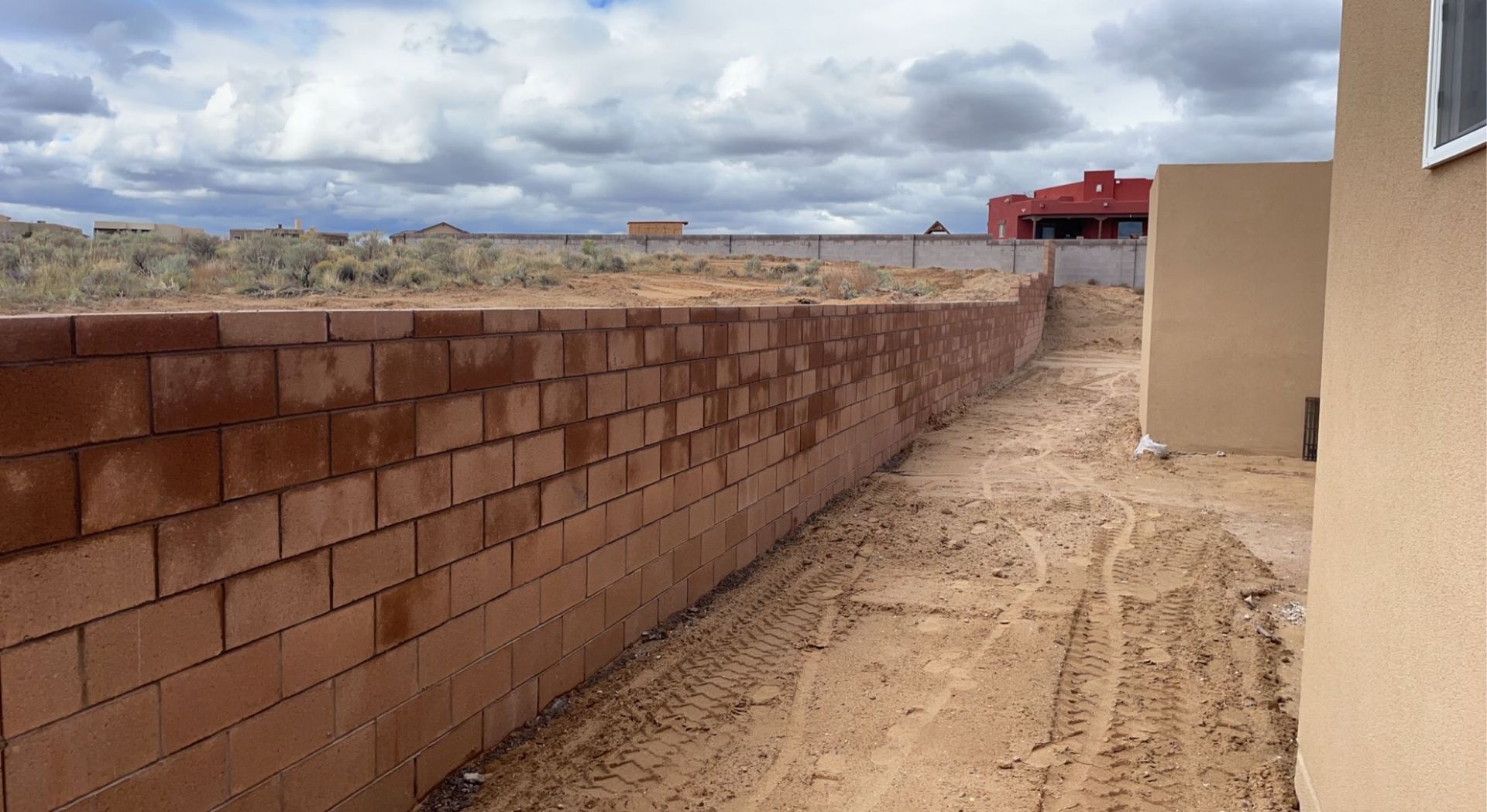 A brick wall is being built next to a building.