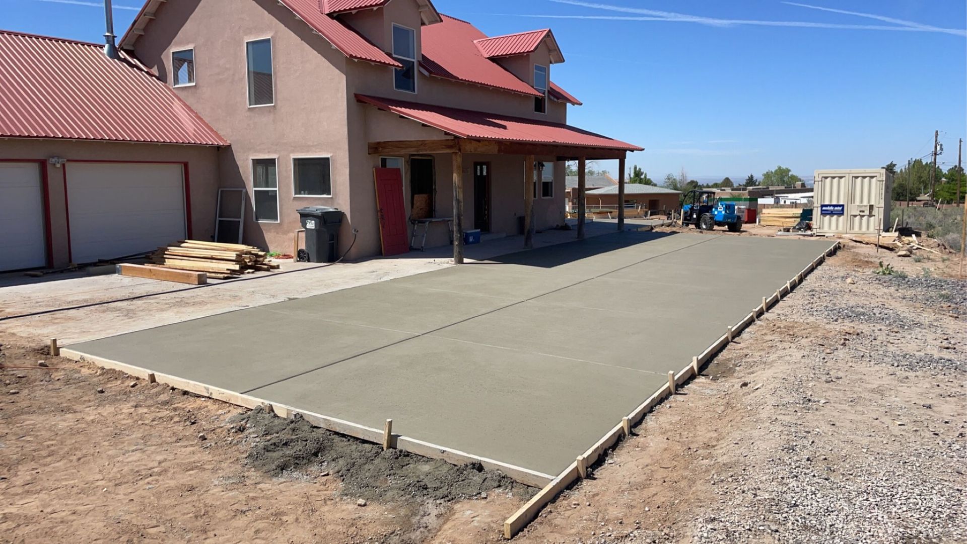 A concrete driveway is being built in front of a house.