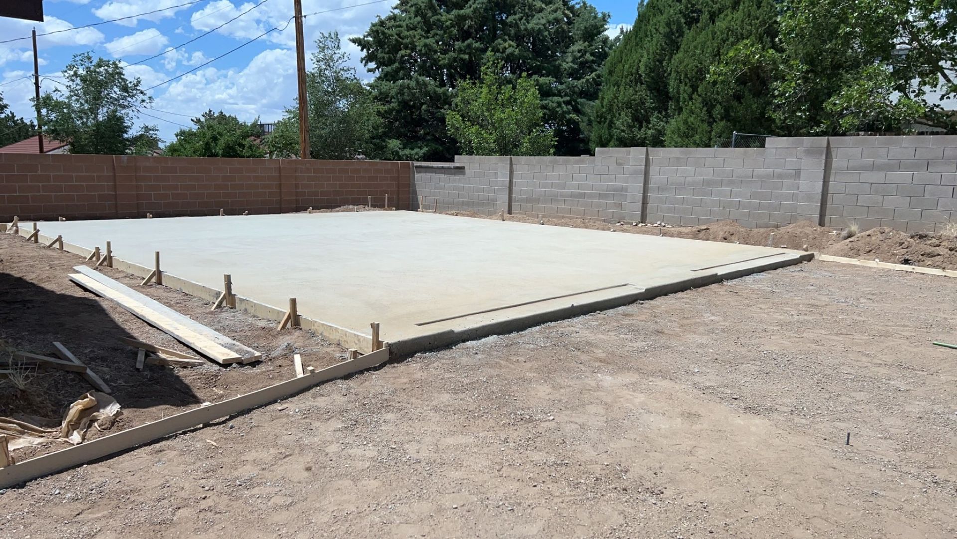 A large concrete slab is sitting on top of a dirt field.