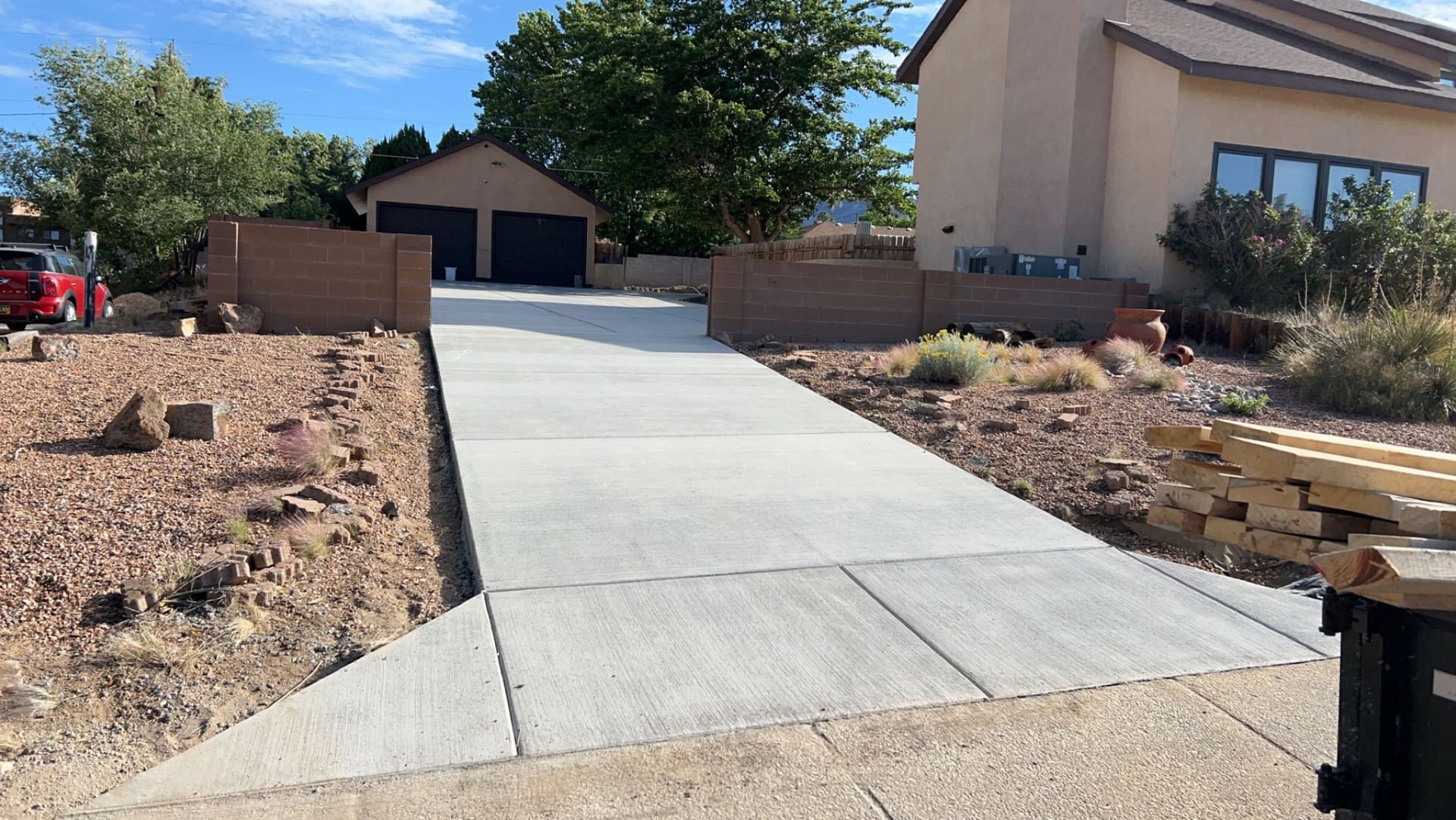 A concrete driveway leading to a house with a garage.
