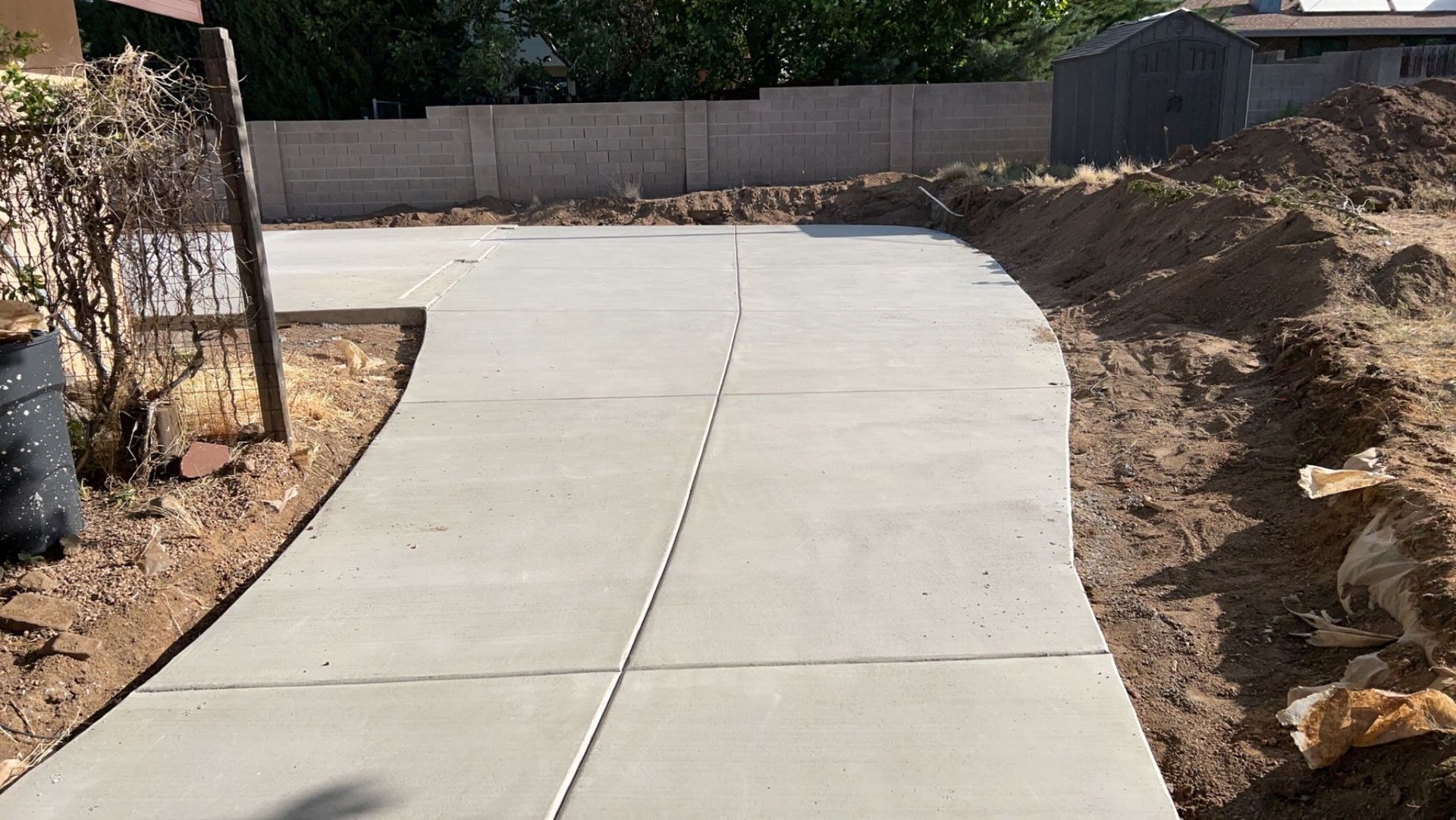 A concrete driveway is being built in a backyard.