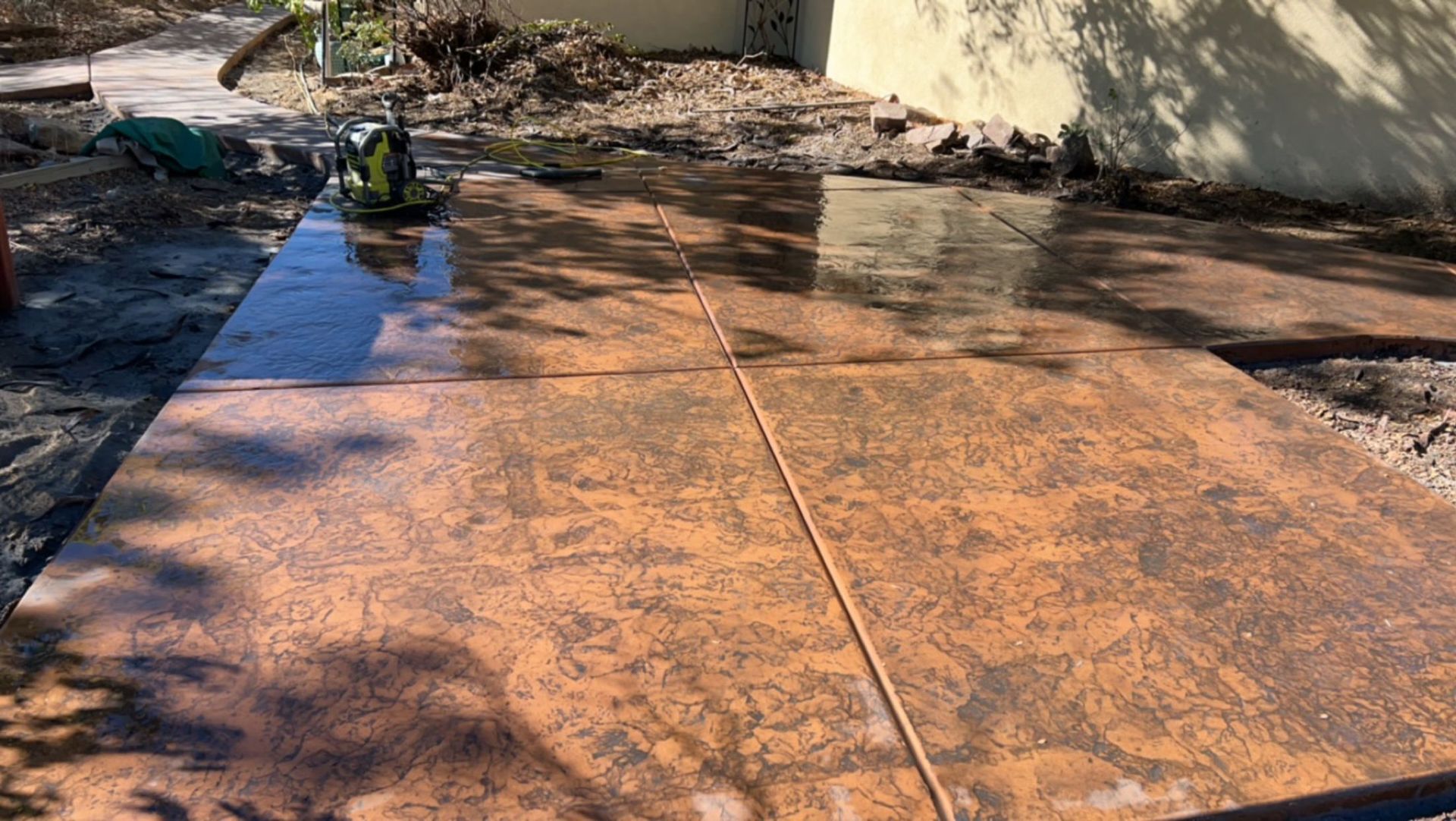 A concrete patio is being built in front of a house.
