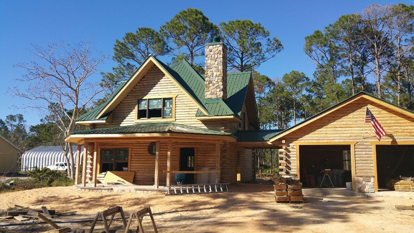 A log cabin with a green roof is being built