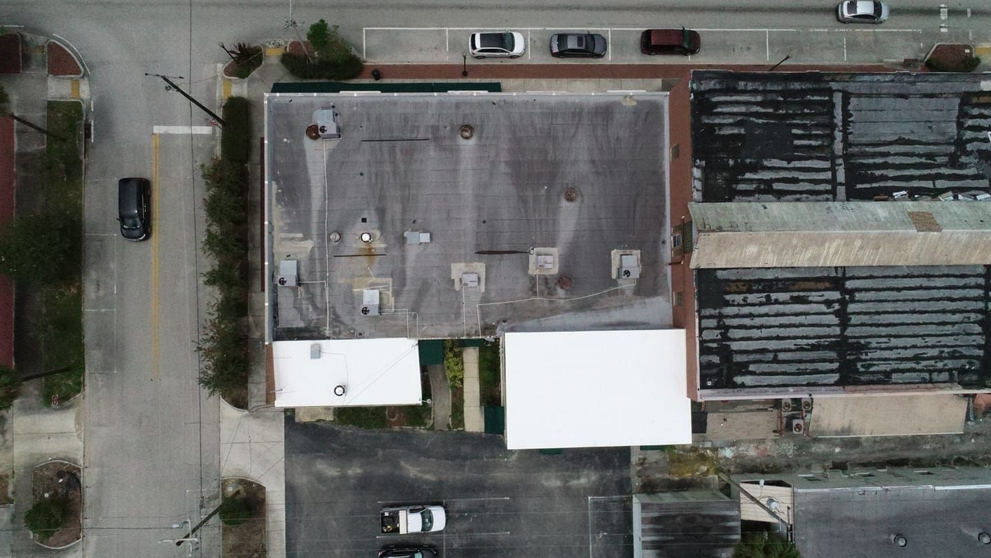 An aerial view of a building with cars parked in front of it.