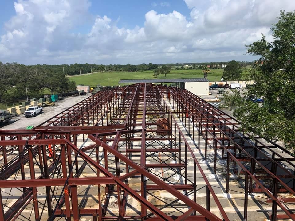 A large metal structure is being built on a sunny day.