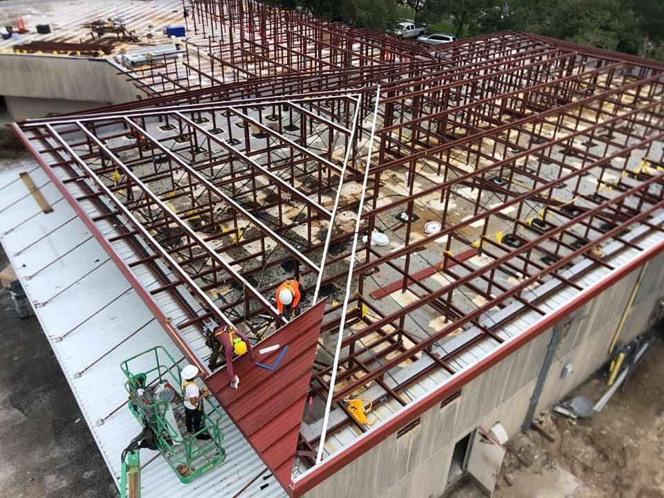 A group of construction workers are working on the roof of a building.