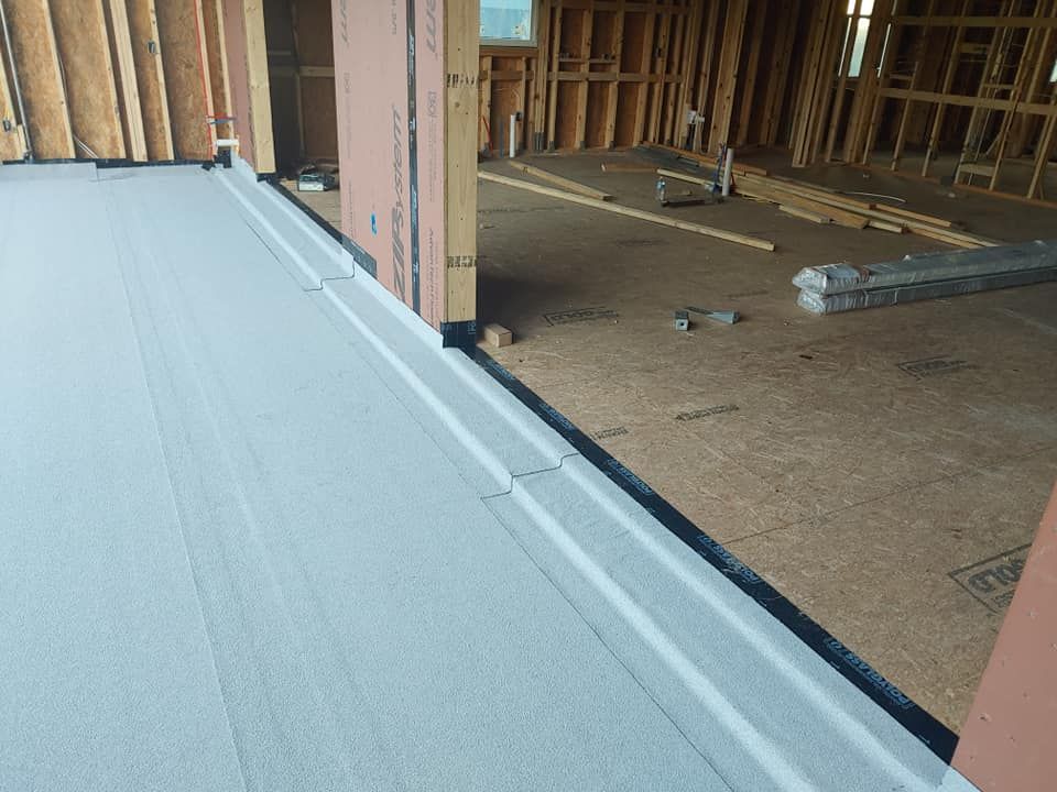 A room in a house under construction with a gray floor.