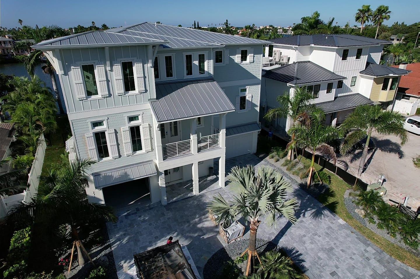 An aerial view of a large white house with a gray roof
