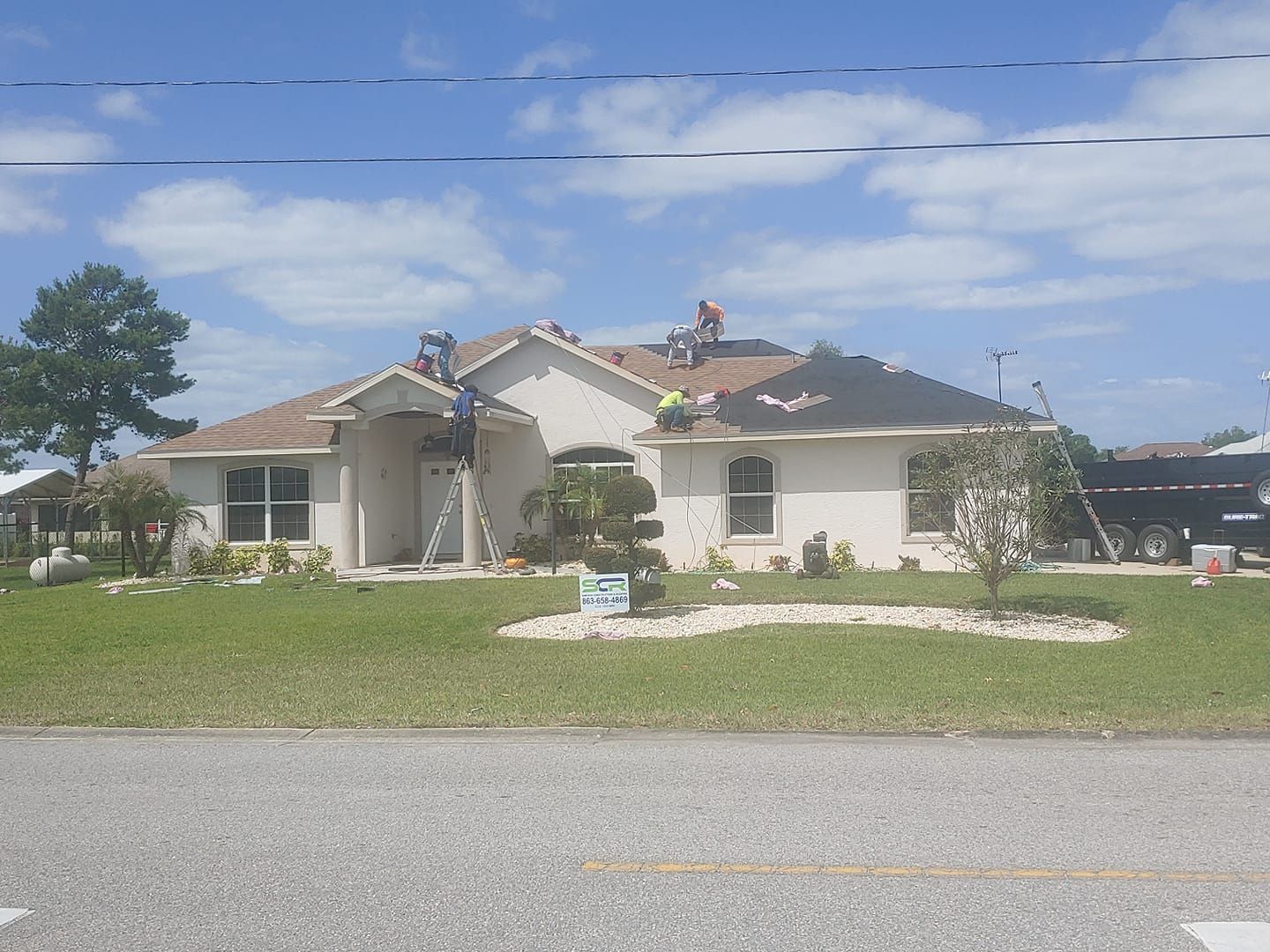 Two men are working on the roof of a house.