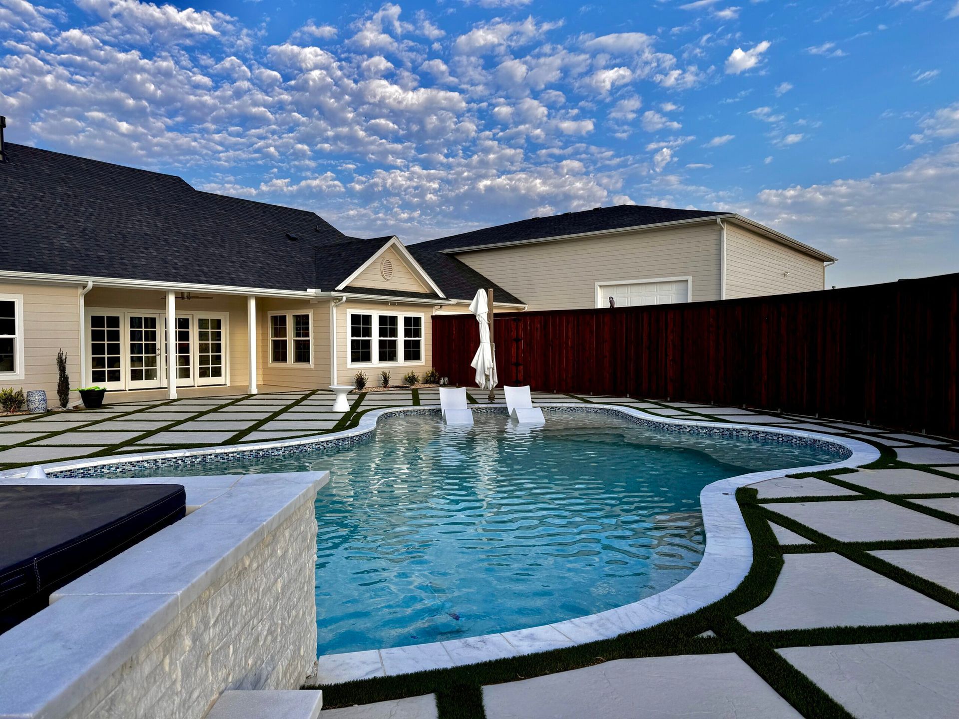 A large swimming pool in the backyard of a house