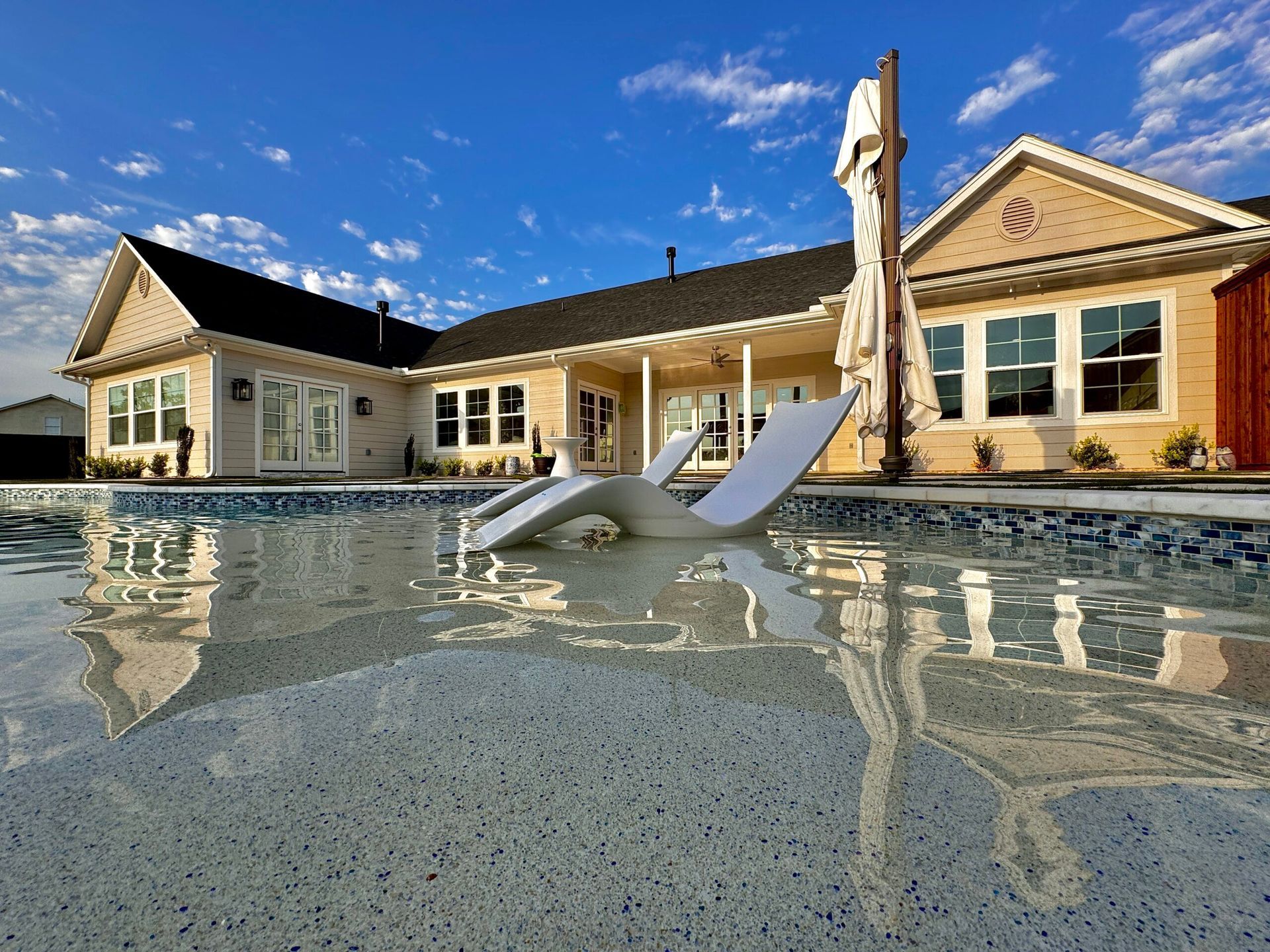 A large house with a swimming pool in front of it