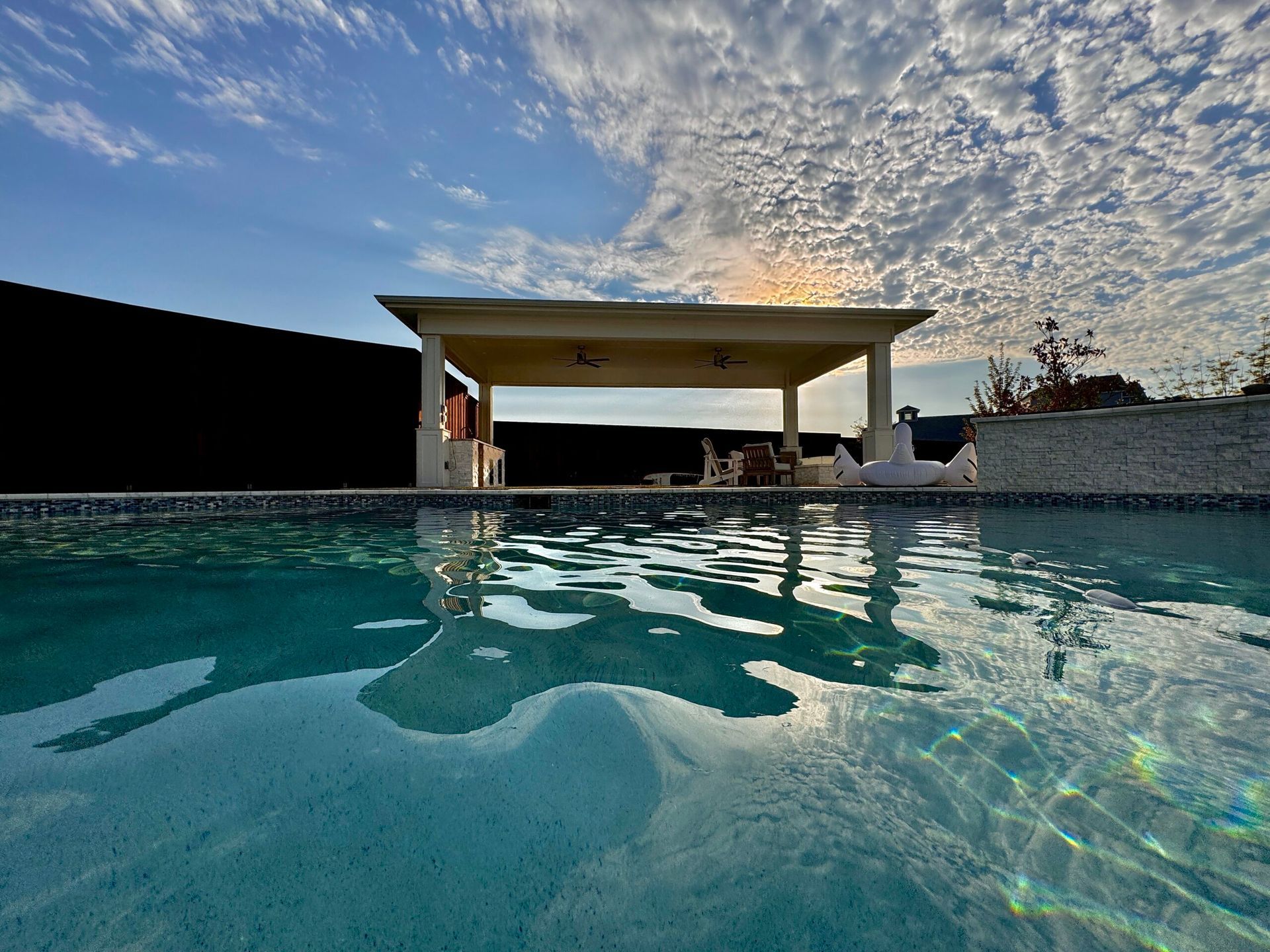 A large swimming pool with a gazebo in the background.