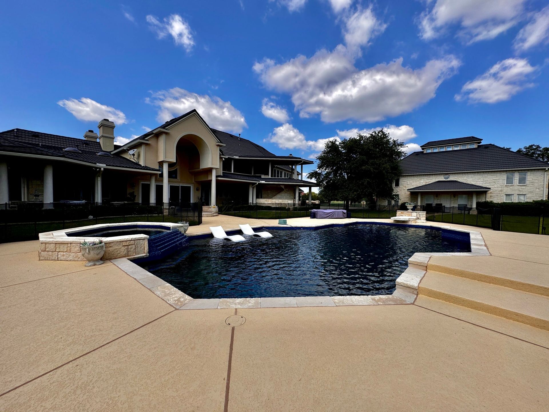 A large house with a large swimming pool in front of it