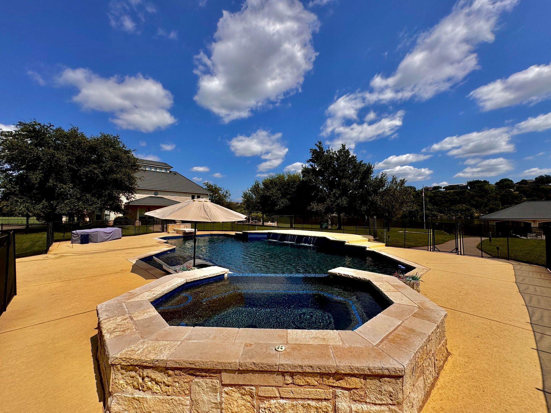 A large swimming pool with a hot tub in the middle