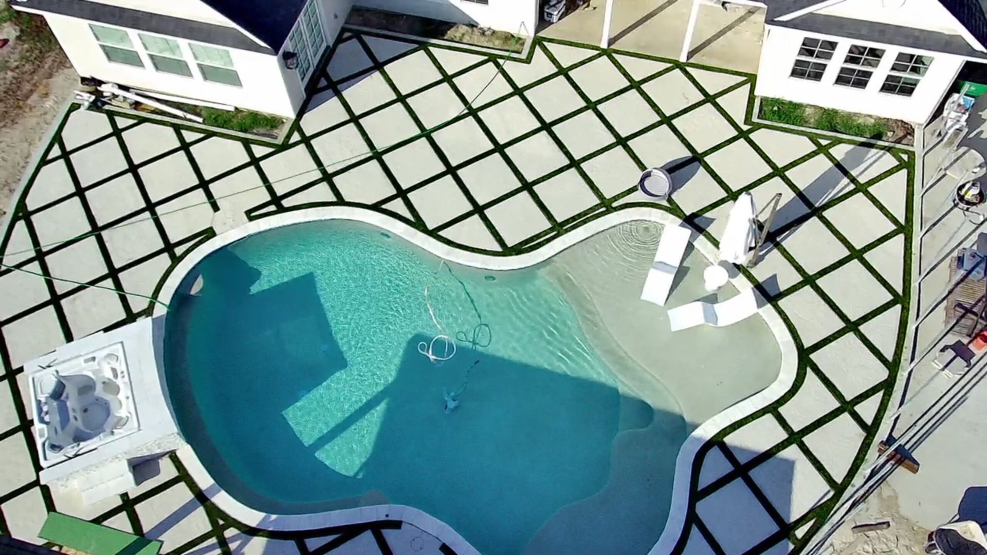 An aerial view of a large swimming pool in a backyard.