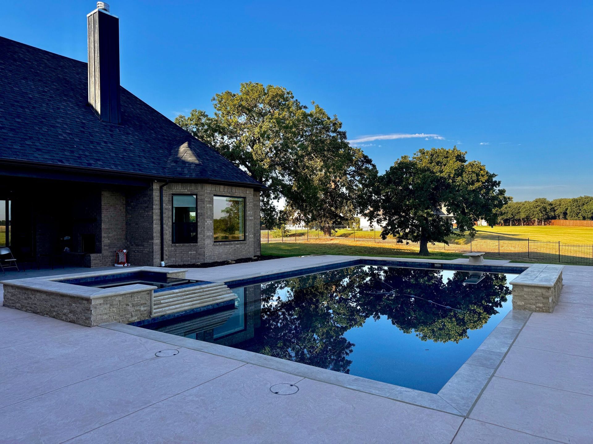 A house with a large swimming pool in front of it
