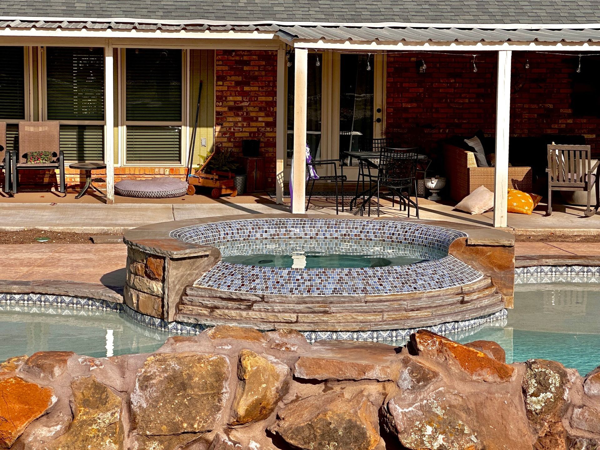 A house with a swimming pool and a hot tub in front of it