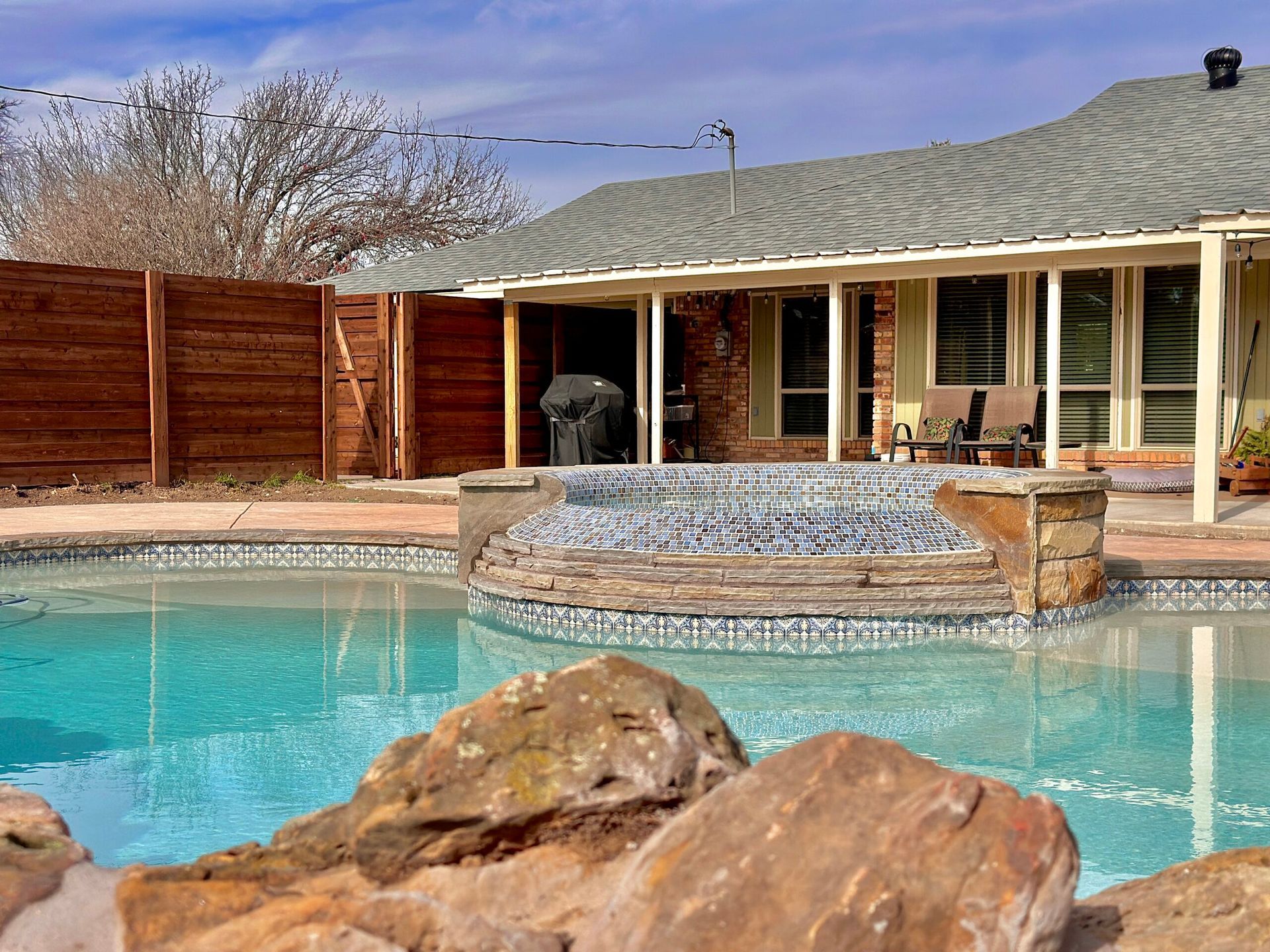 A house with a large swimming pool in front of it