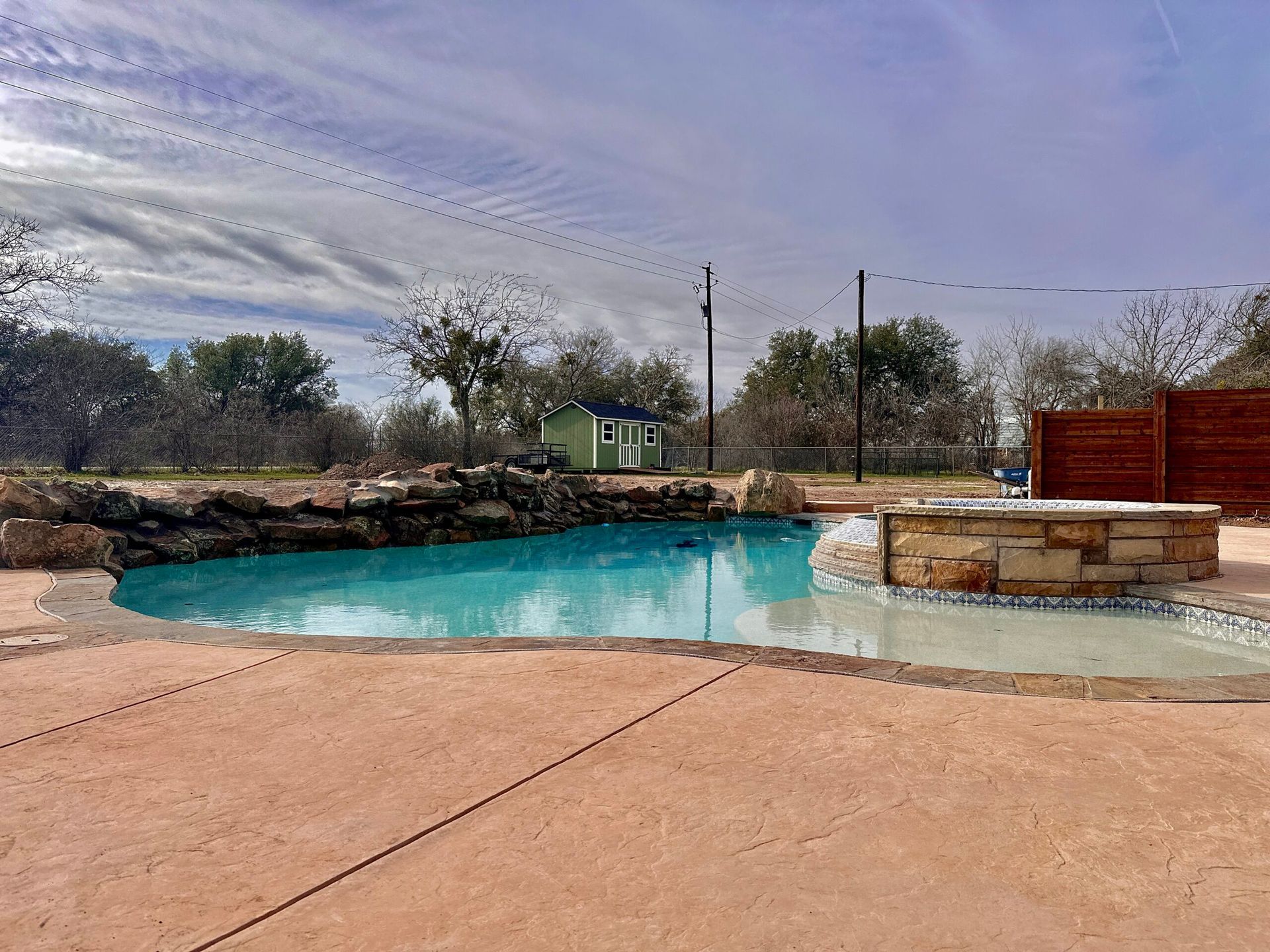 There is a large swimming pool in the backyard of a house.