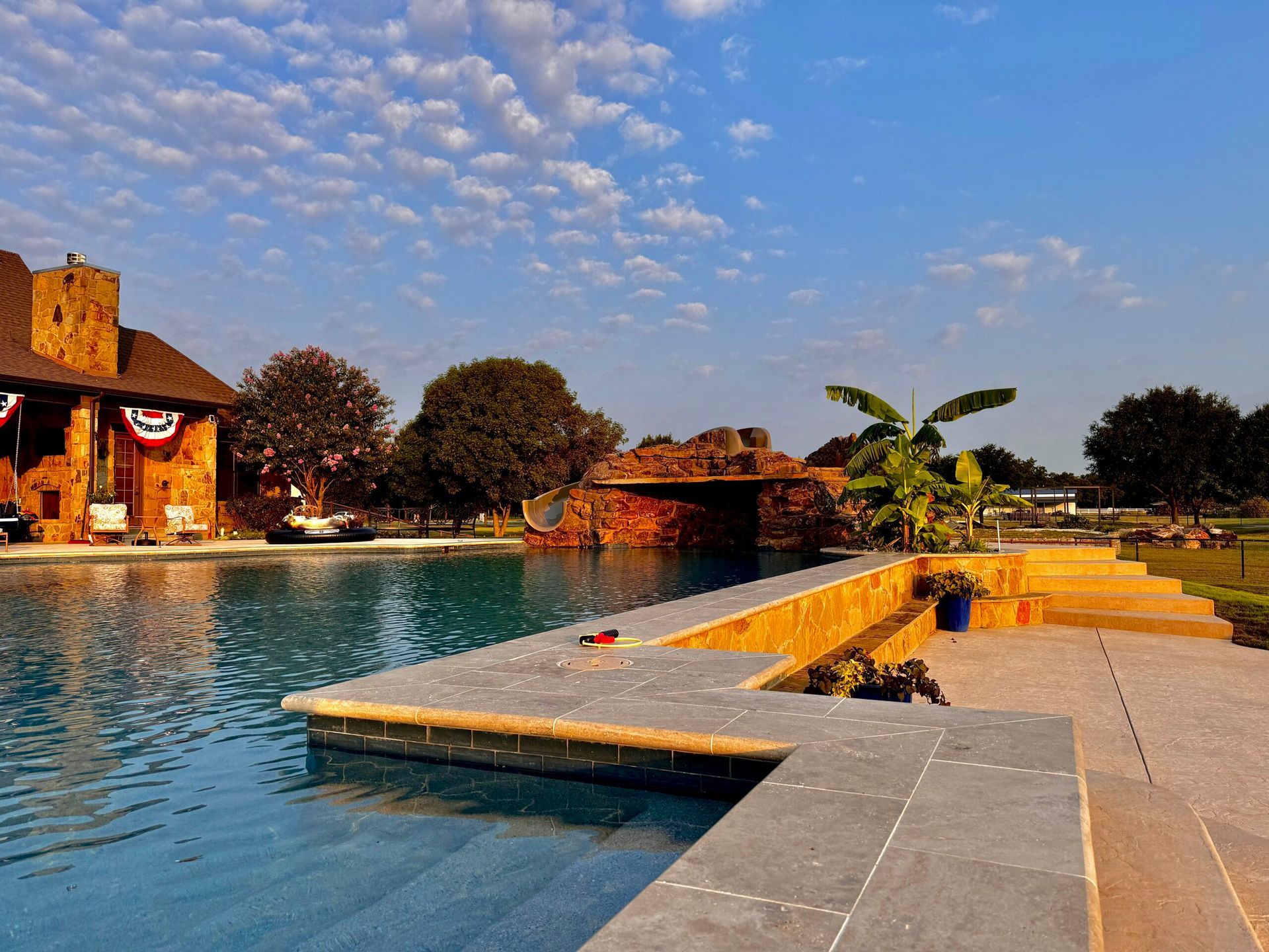 A large swimming pool with a house in the background
