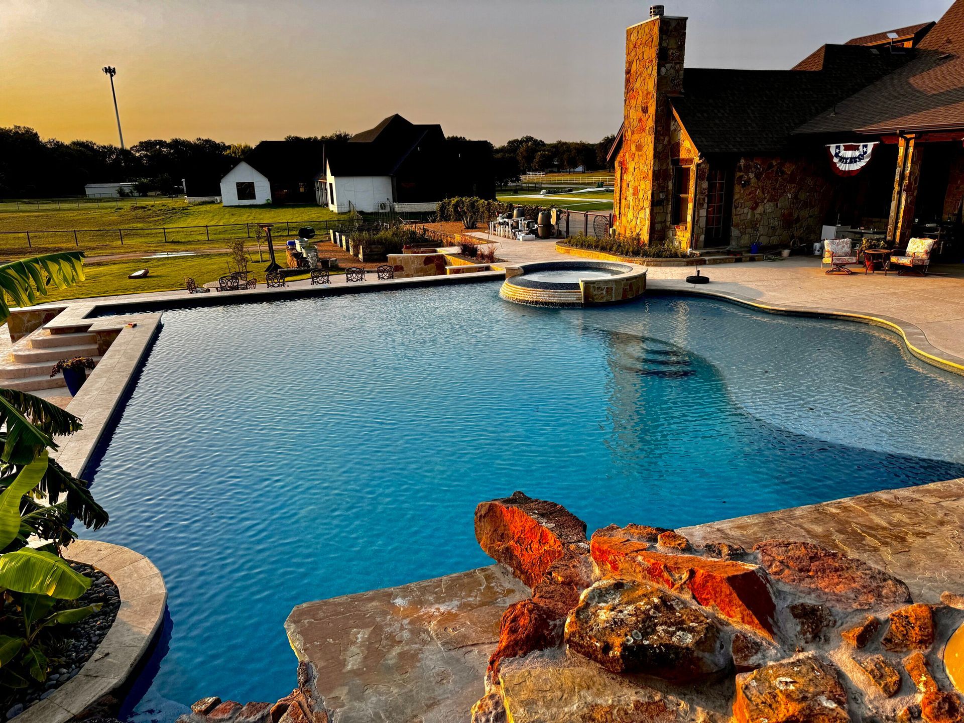 A large swimming pool with a house in the background