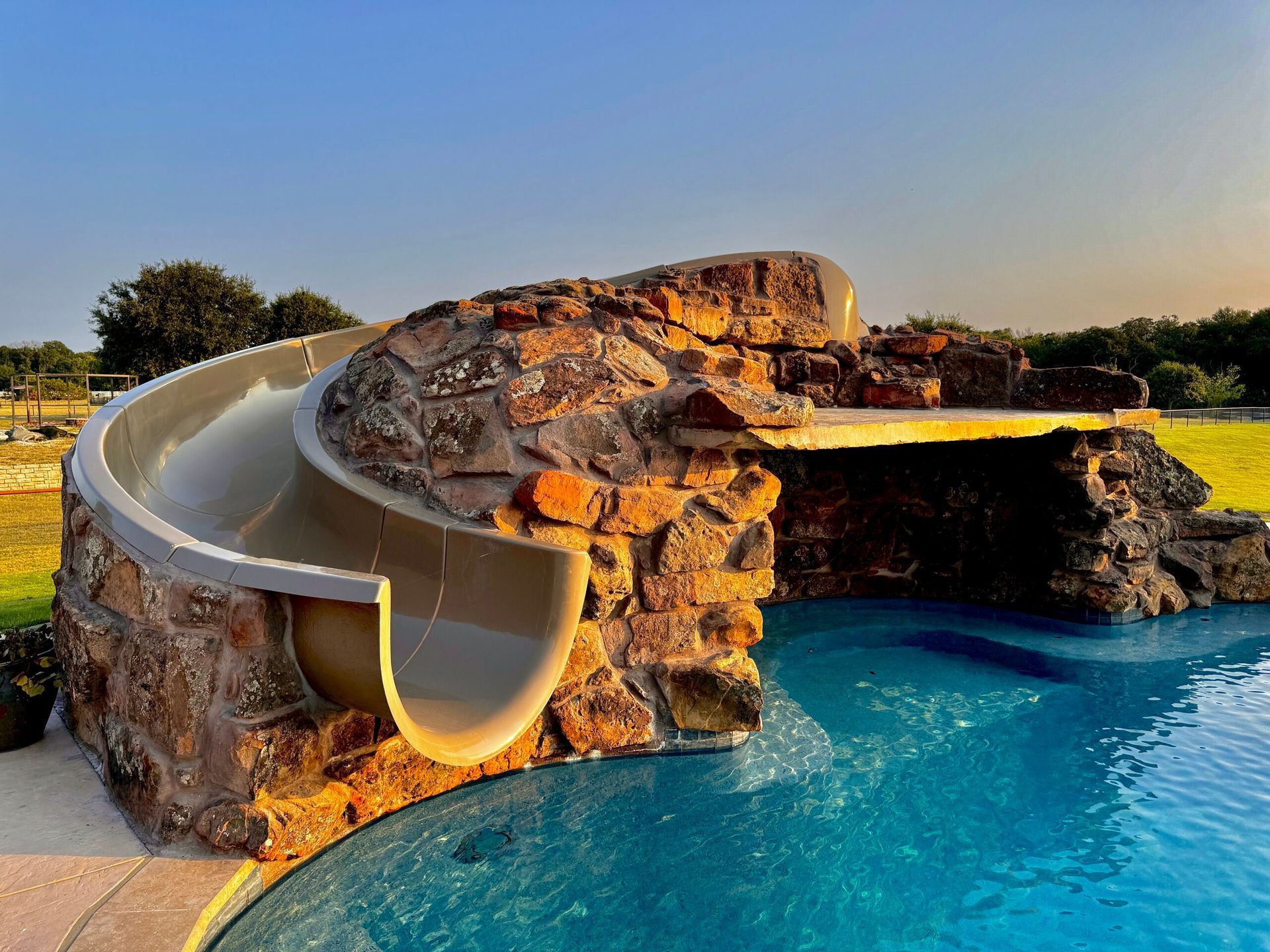 A water slide is built into the side of a swimming pool
