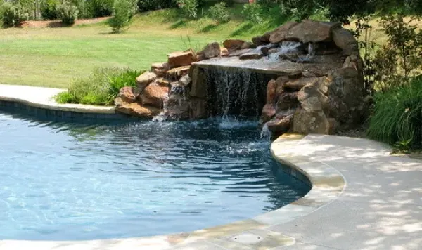 A swimming pool with a waterfall in the middle of it