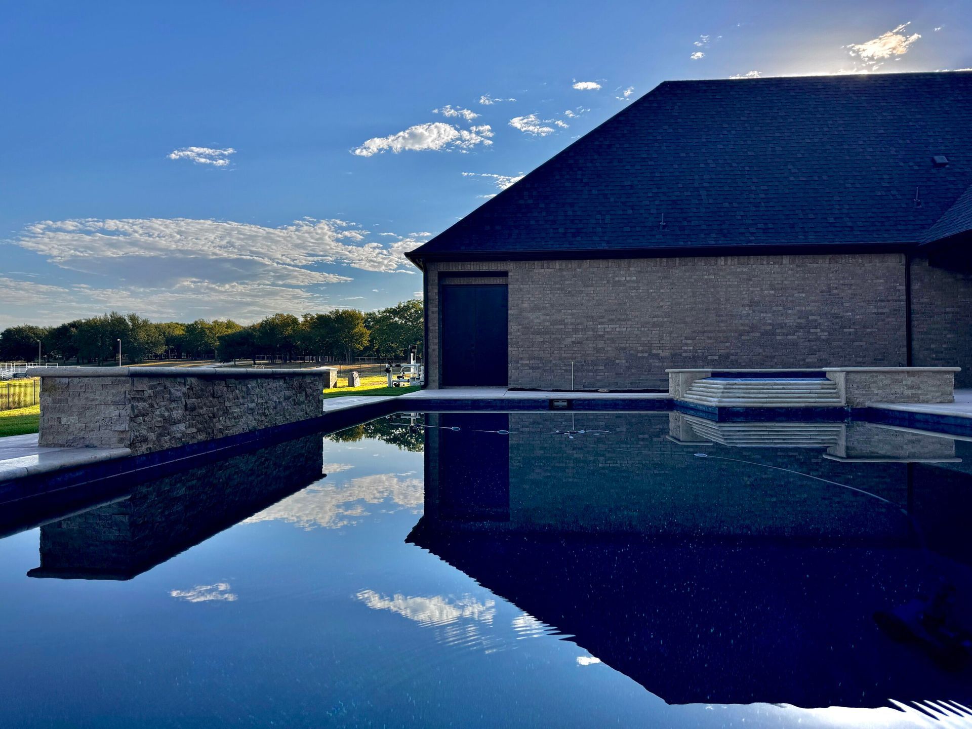A large house with a large swimming pool in front of it.