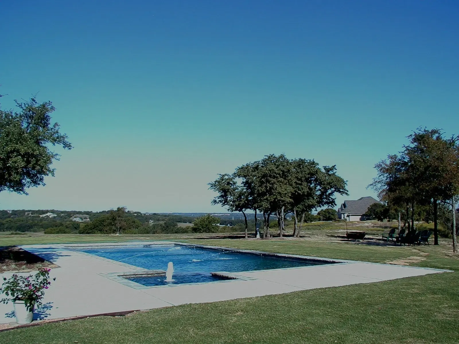 A large swimming pool with a fountain in the middle