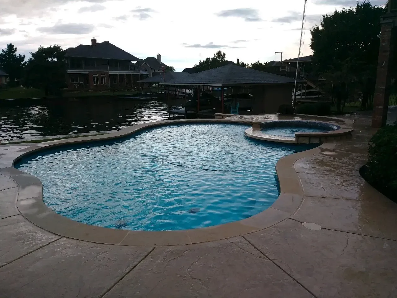 A large swimming pool with a hot tub in the middle