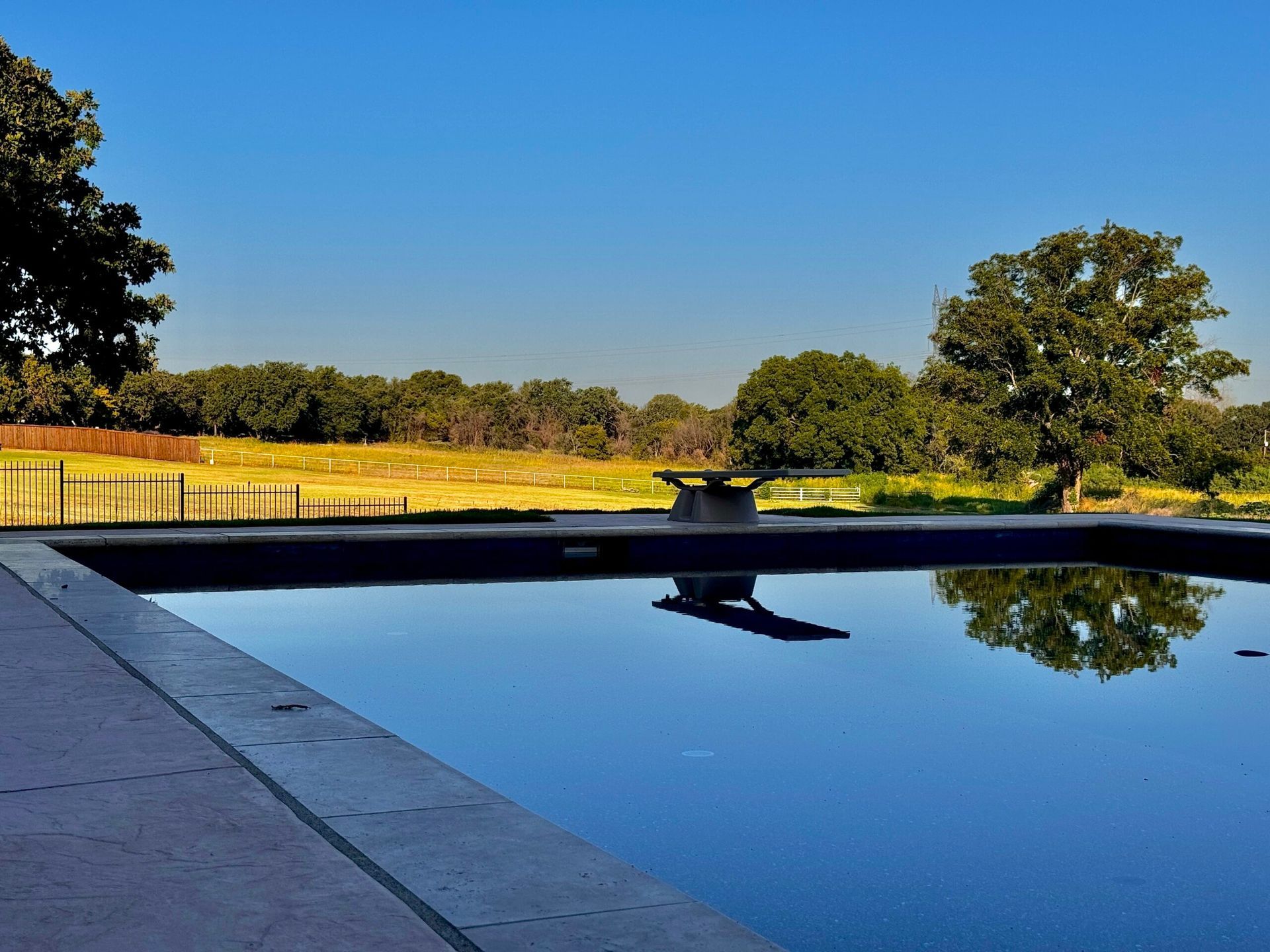 A large swimming pool with trees in the background