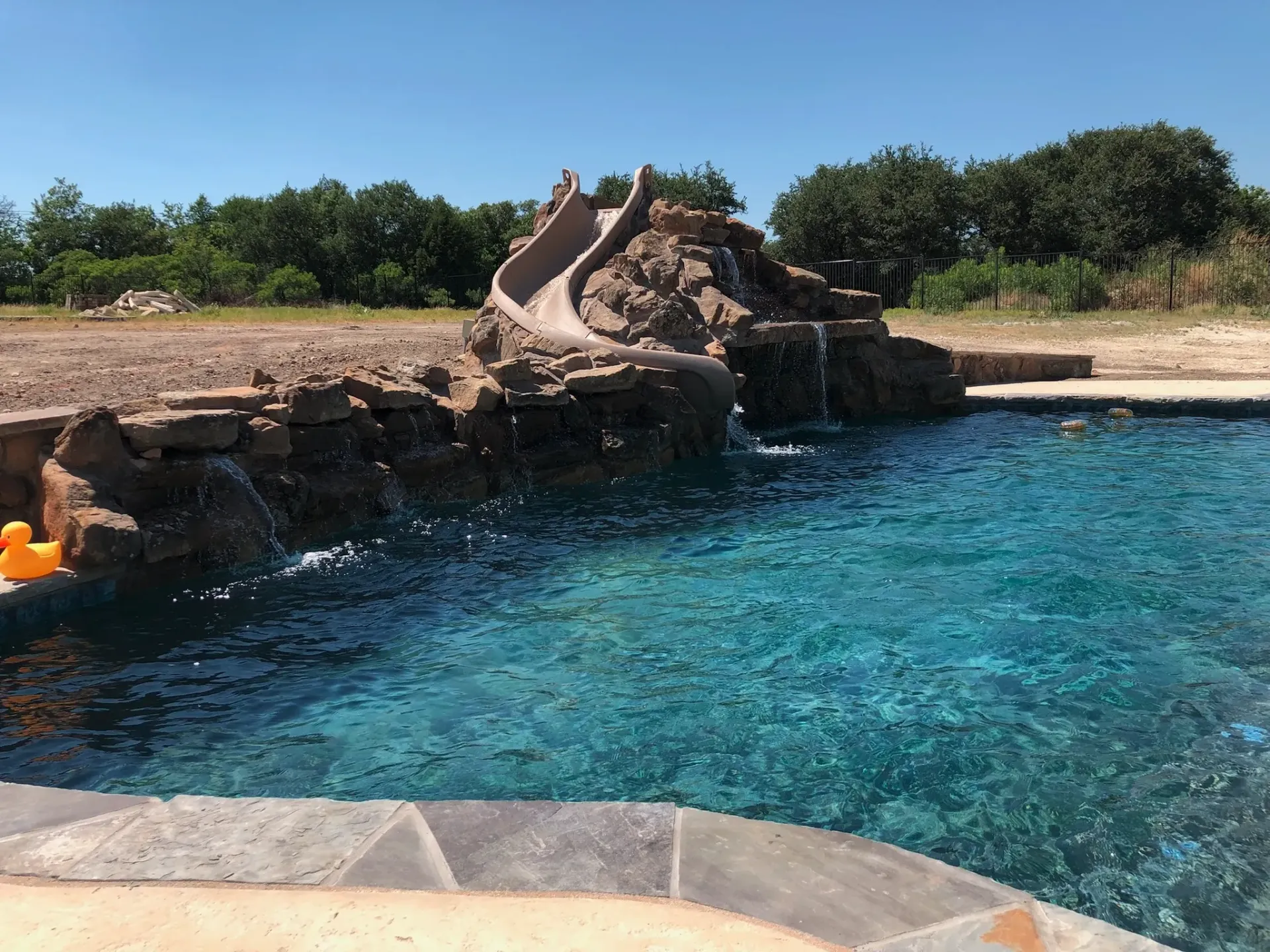 There is a water slide in the middle of the pool.
