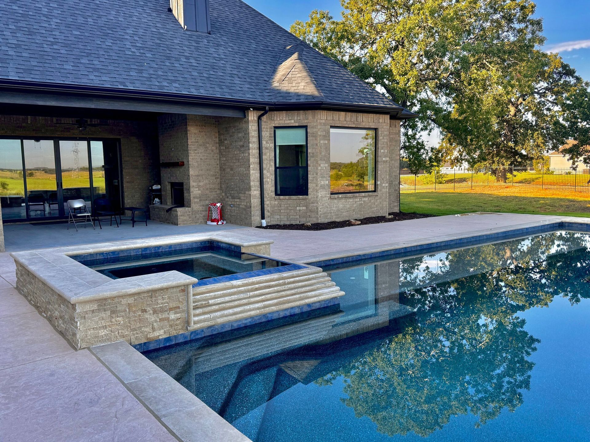 There is a large swimming pool in front of a house.