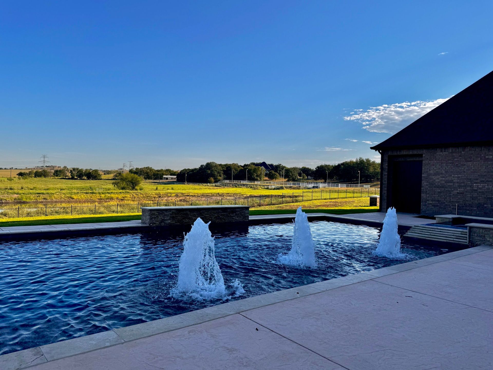 A swimming pool with a fountain in the middle of it