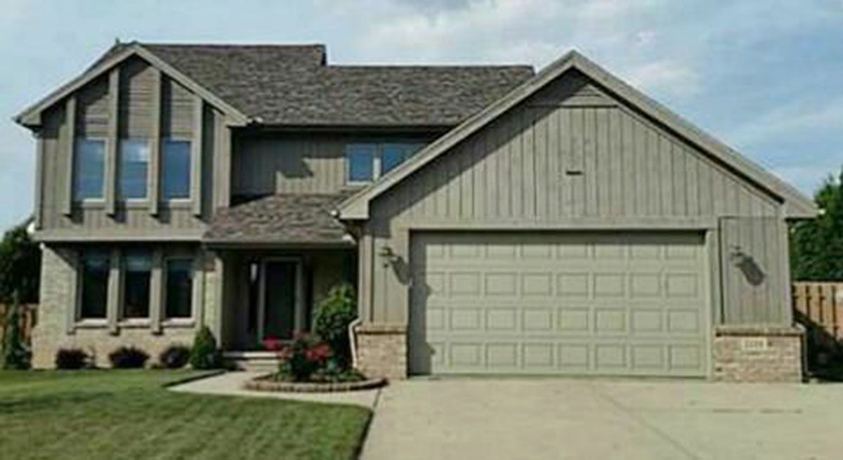 Two-story house with gray siding, gray roof, and a two-car garage