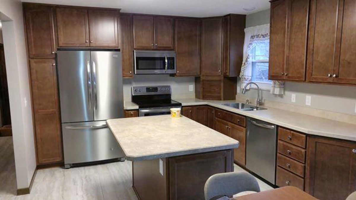 Kitchen with brown cabinets, stainless steel appliances, and a light-colored countertop