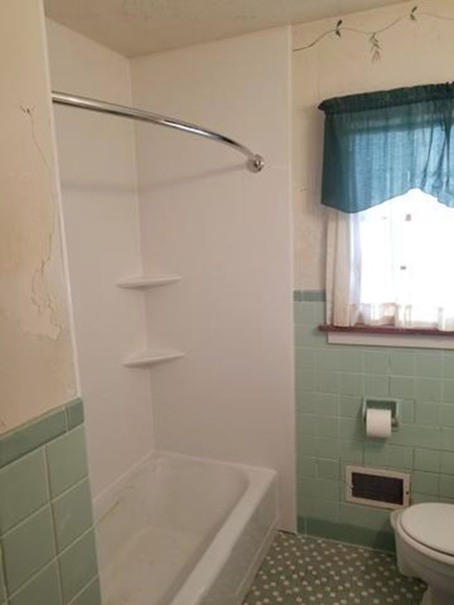 Bathroom with a white shower and blue-green tiled wall