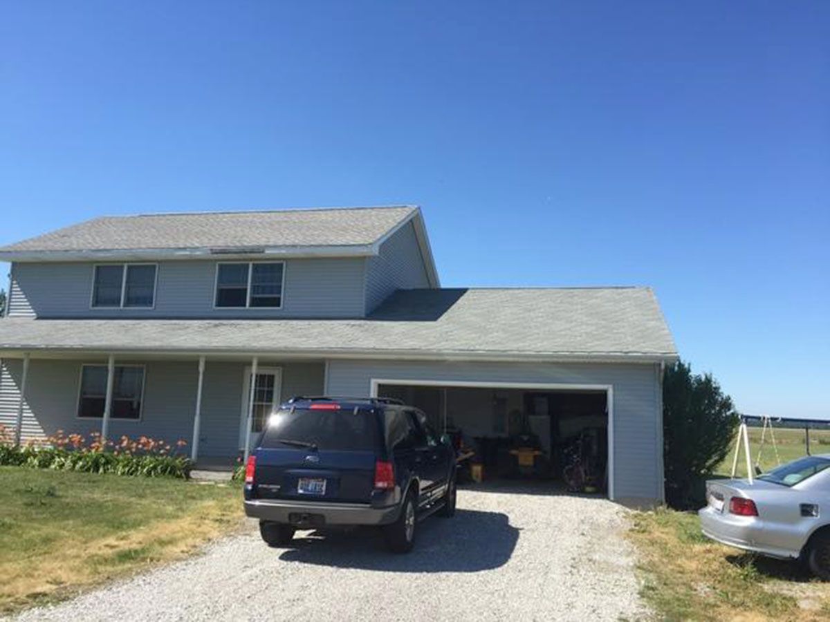Blue house with attached garage and a blue SUV in the driveway