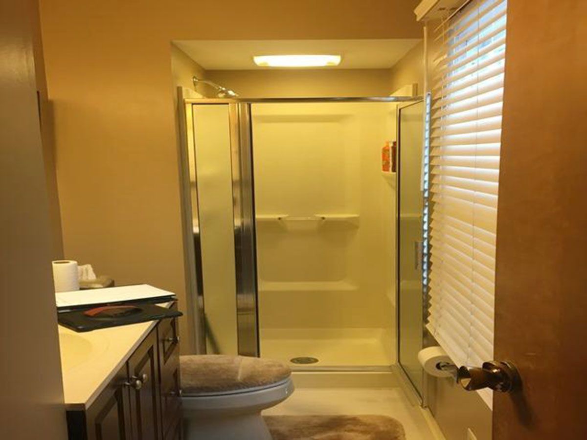 Bathroom interior with a shower, toilet, and vanity