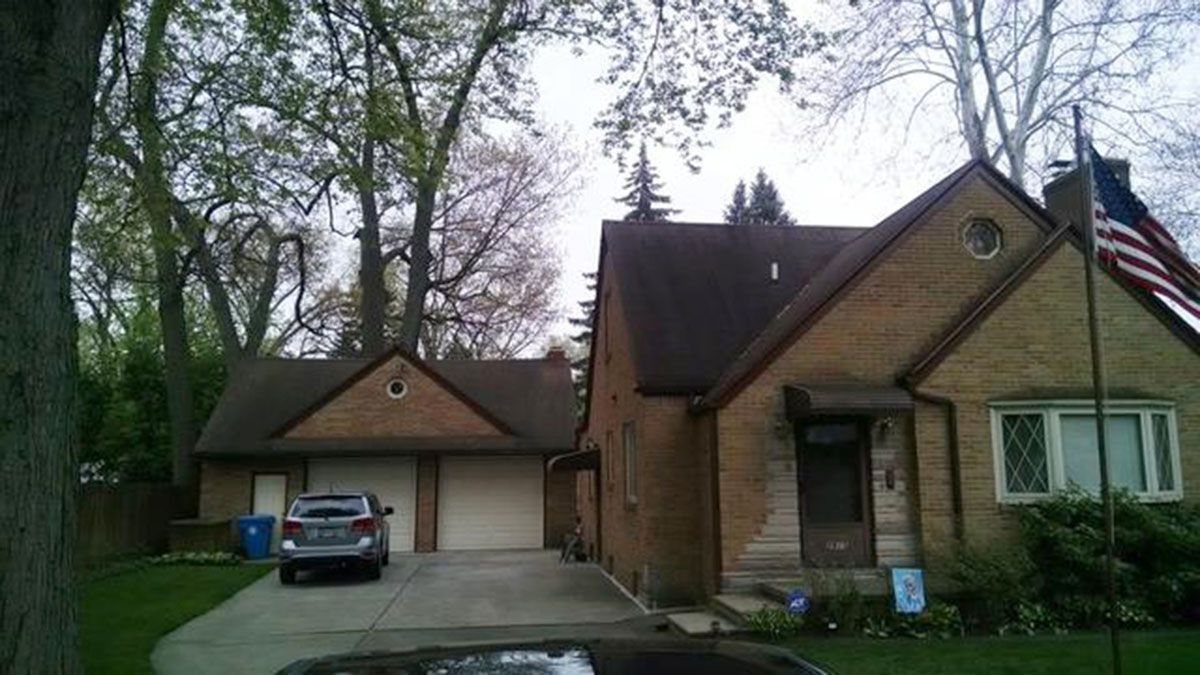 Brick house with a garage, driveway, and American flag on a pole