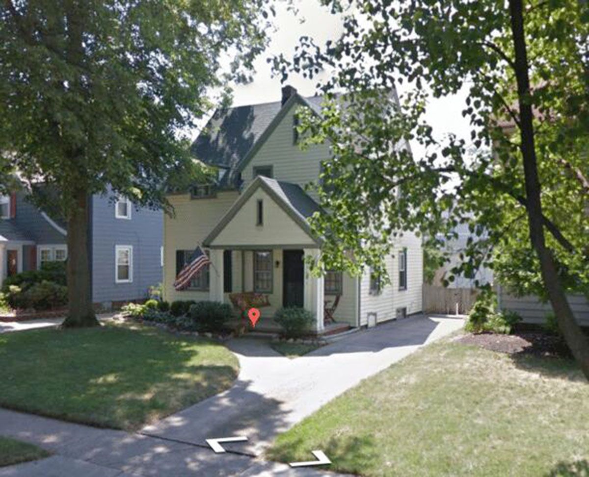 Two-story light house with porch and driveway