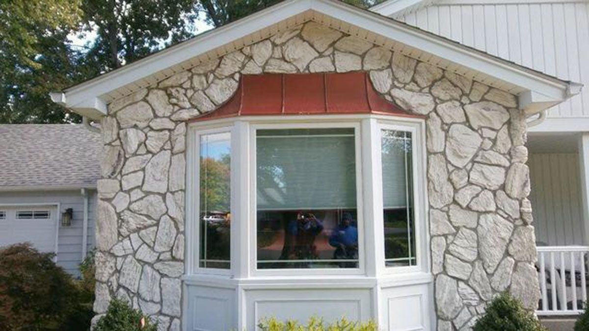 Stone-clad house with bay window and copper roof detail