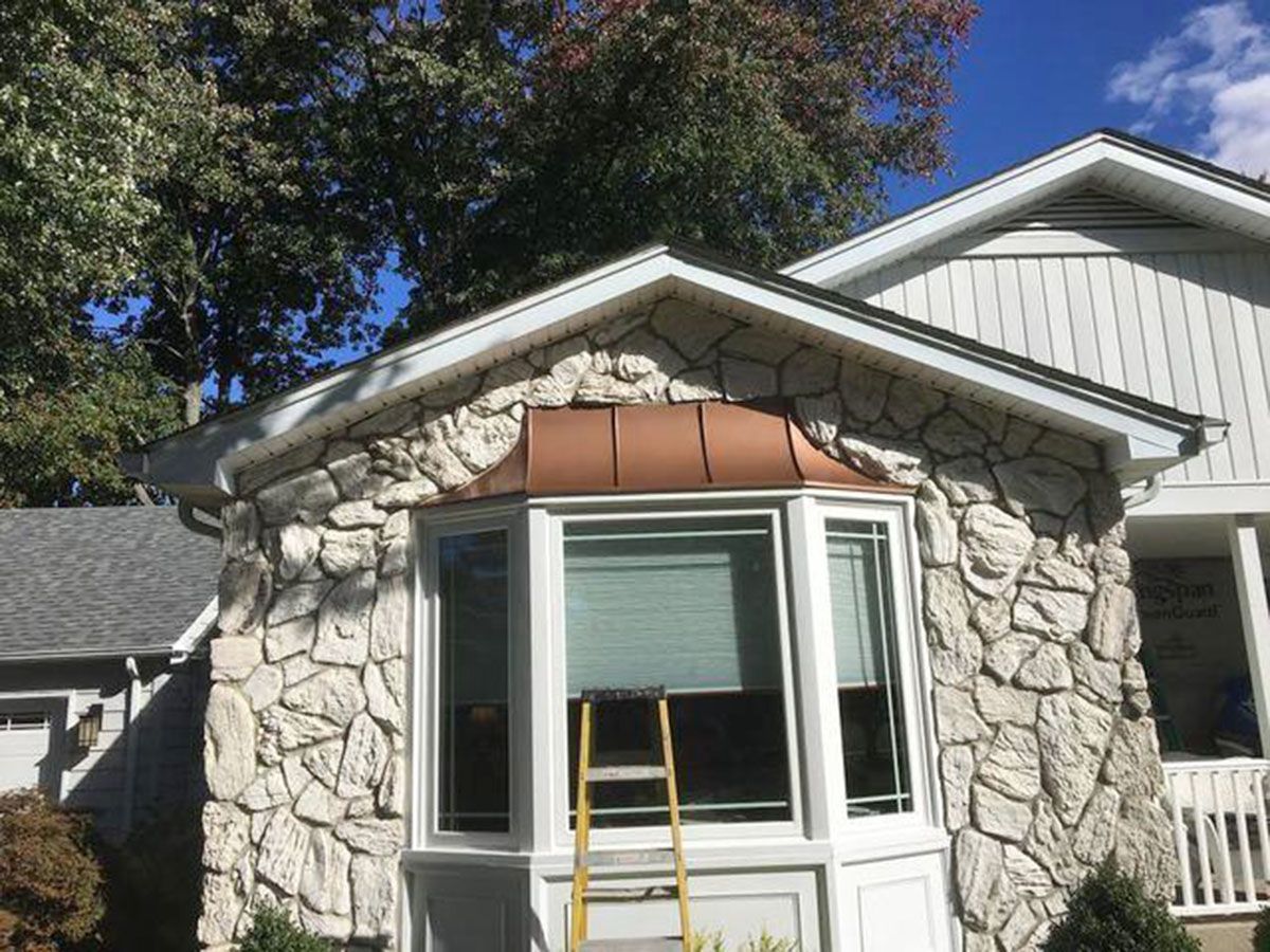 Stone facade bay window with copper roofing