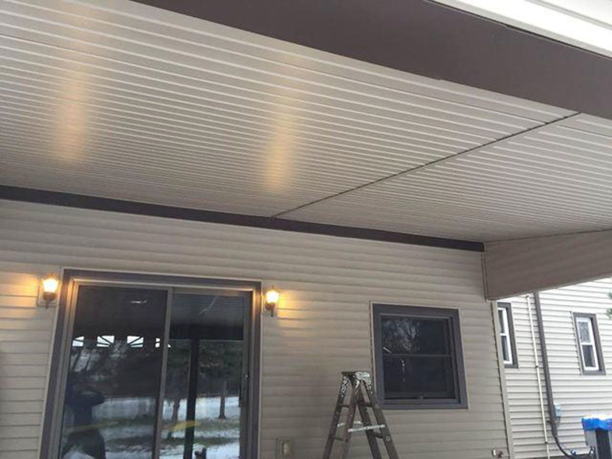 Covered patio with beige siding and a sliding glass door