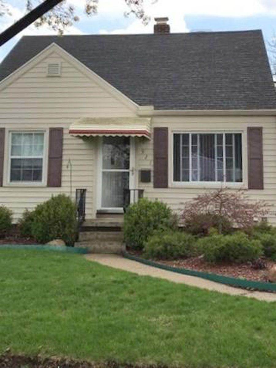Beige house with a dark roof and brown shutters