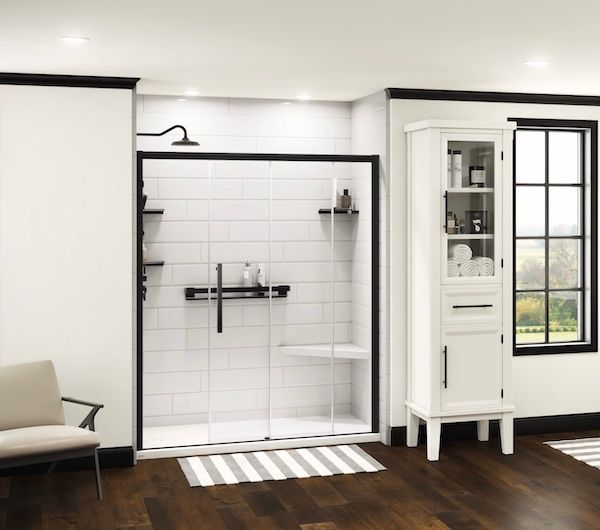 Bathroom with white tile shower, black trim, and cabinet.
