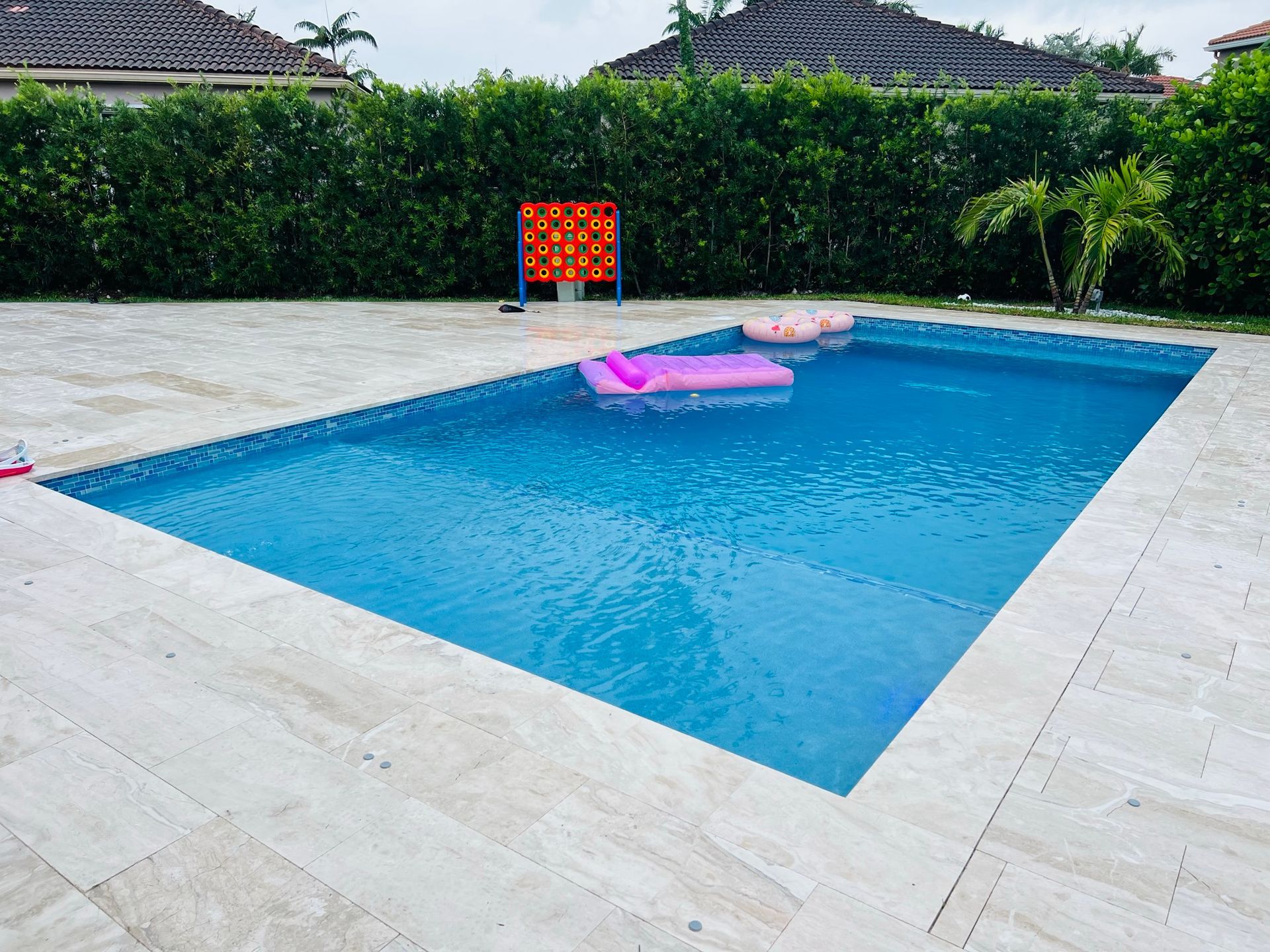 A large swimming pool with a pink raft in it.