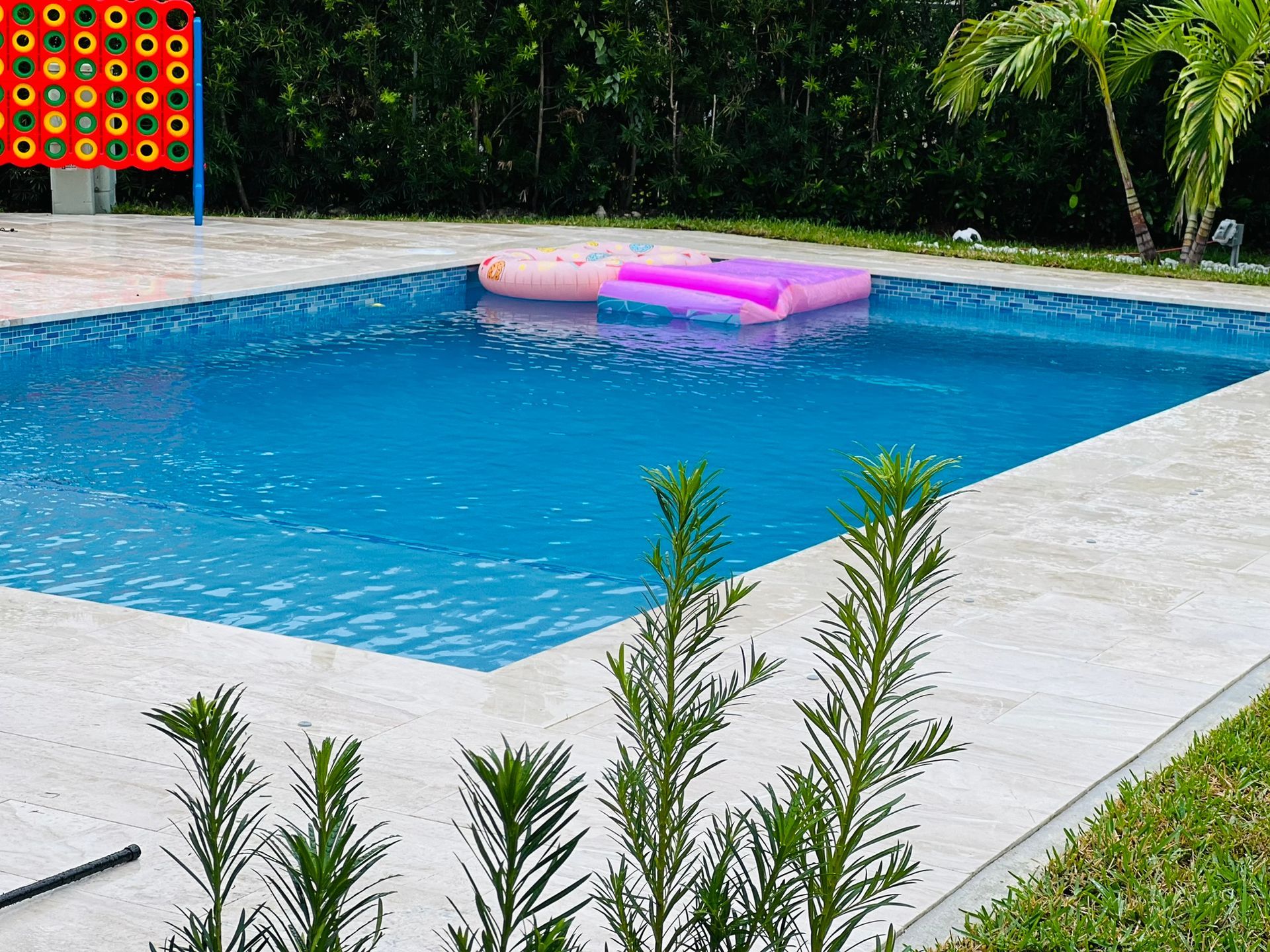 A large swimming pool with a pink raft in it