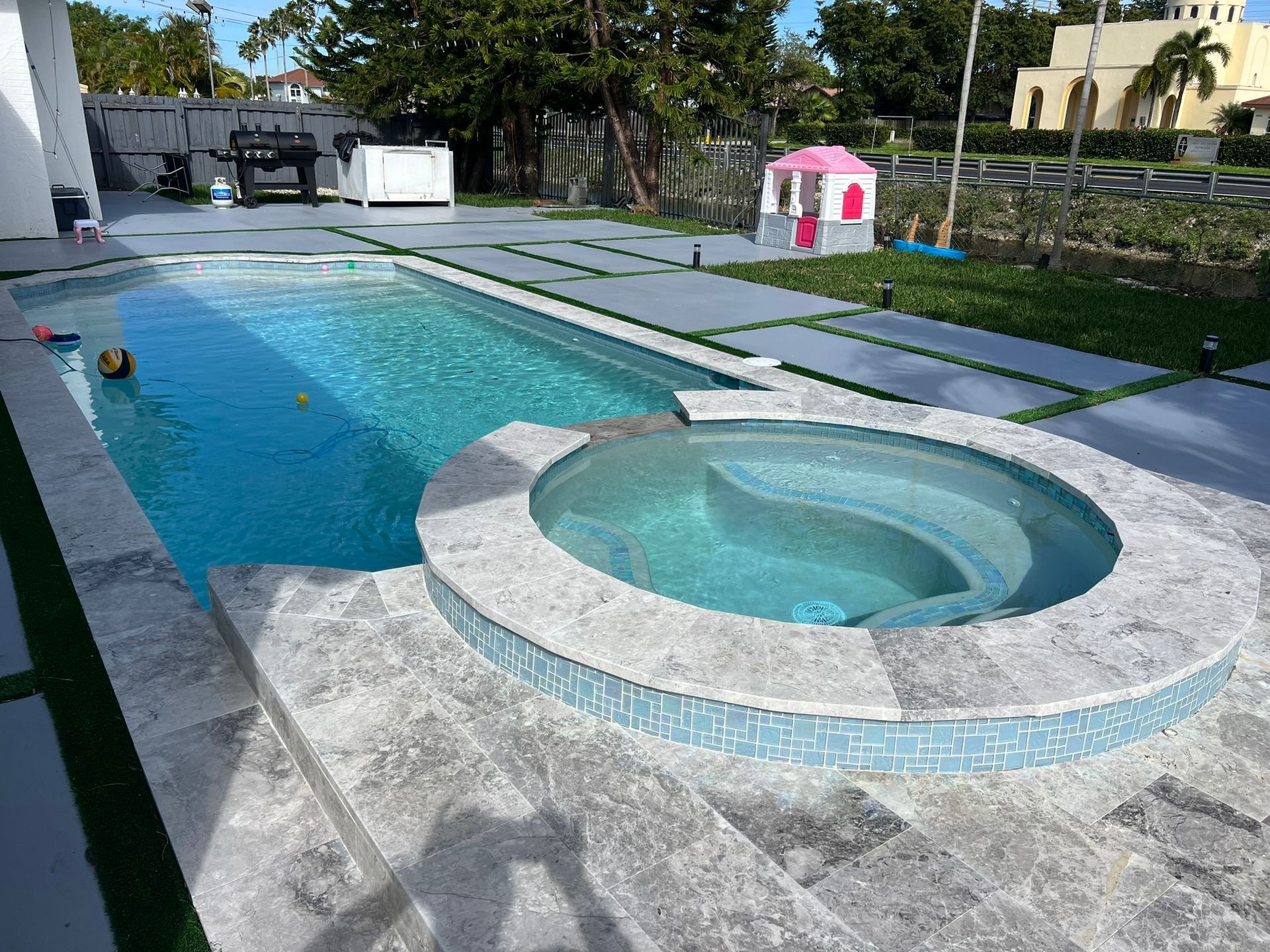 A large swimming pool with a hot tub in the middle of it.