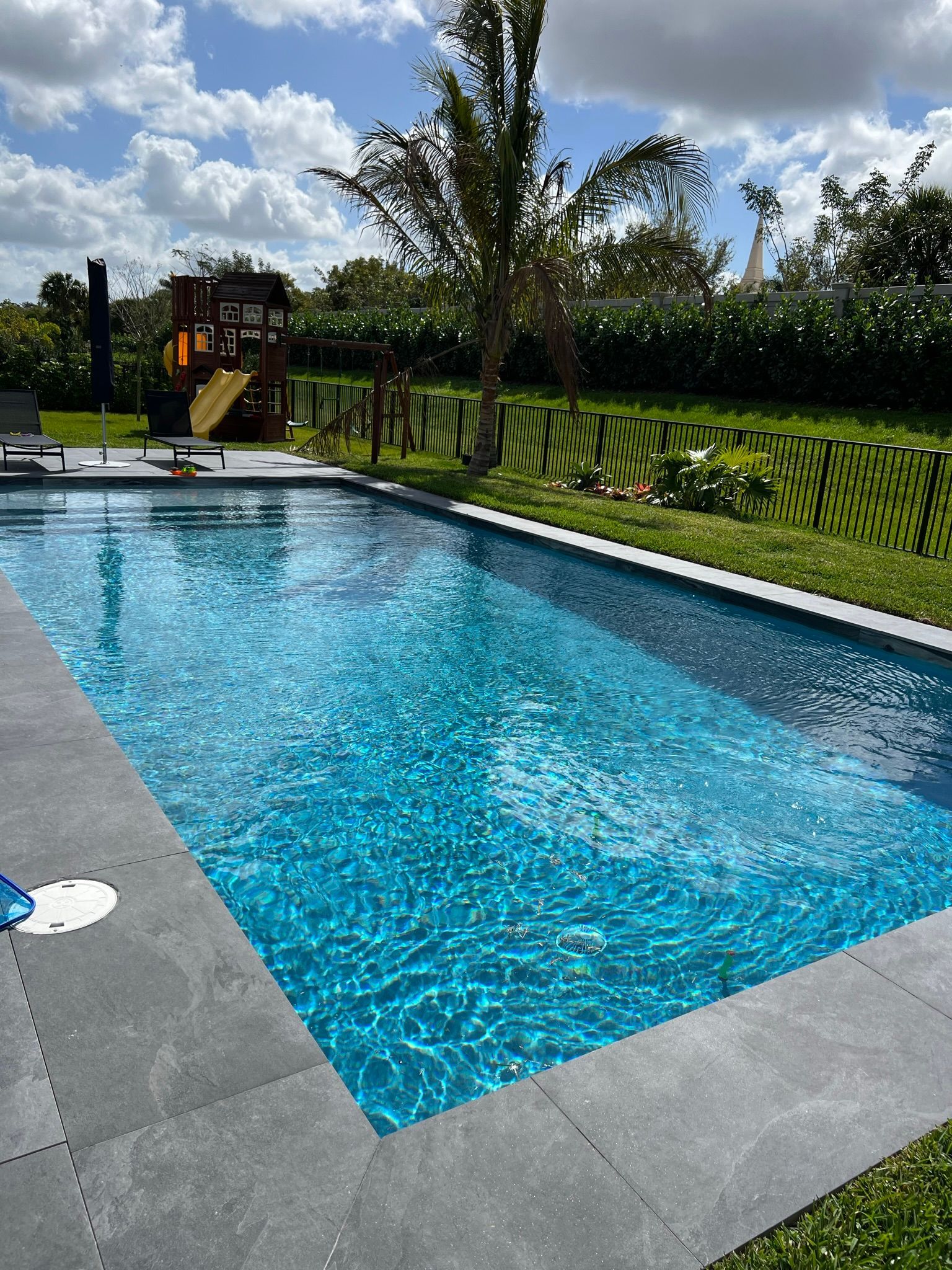 A large swimming pool in the backyard of a house.